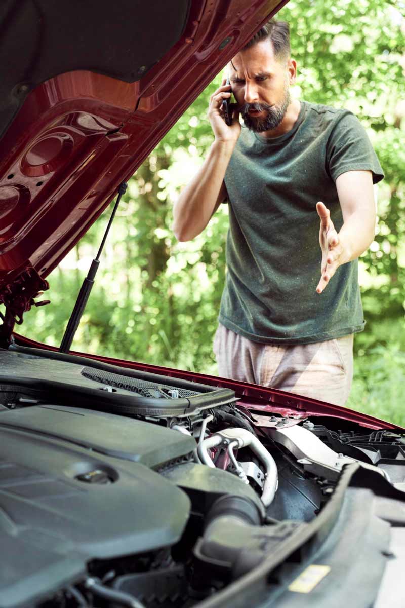 Junger Mann prüft Getriebeschaden bei Schrottauto Ankauf Langenfeld
